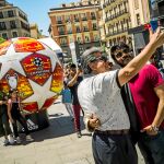 Dos aficionados posan junto a una imagen del balón de la final en la plaza de Callao. Foto: Alberto R. Roldán