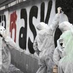 Varios encapuchados realizan una pintada a favor de la amnistía de los presos etarras
