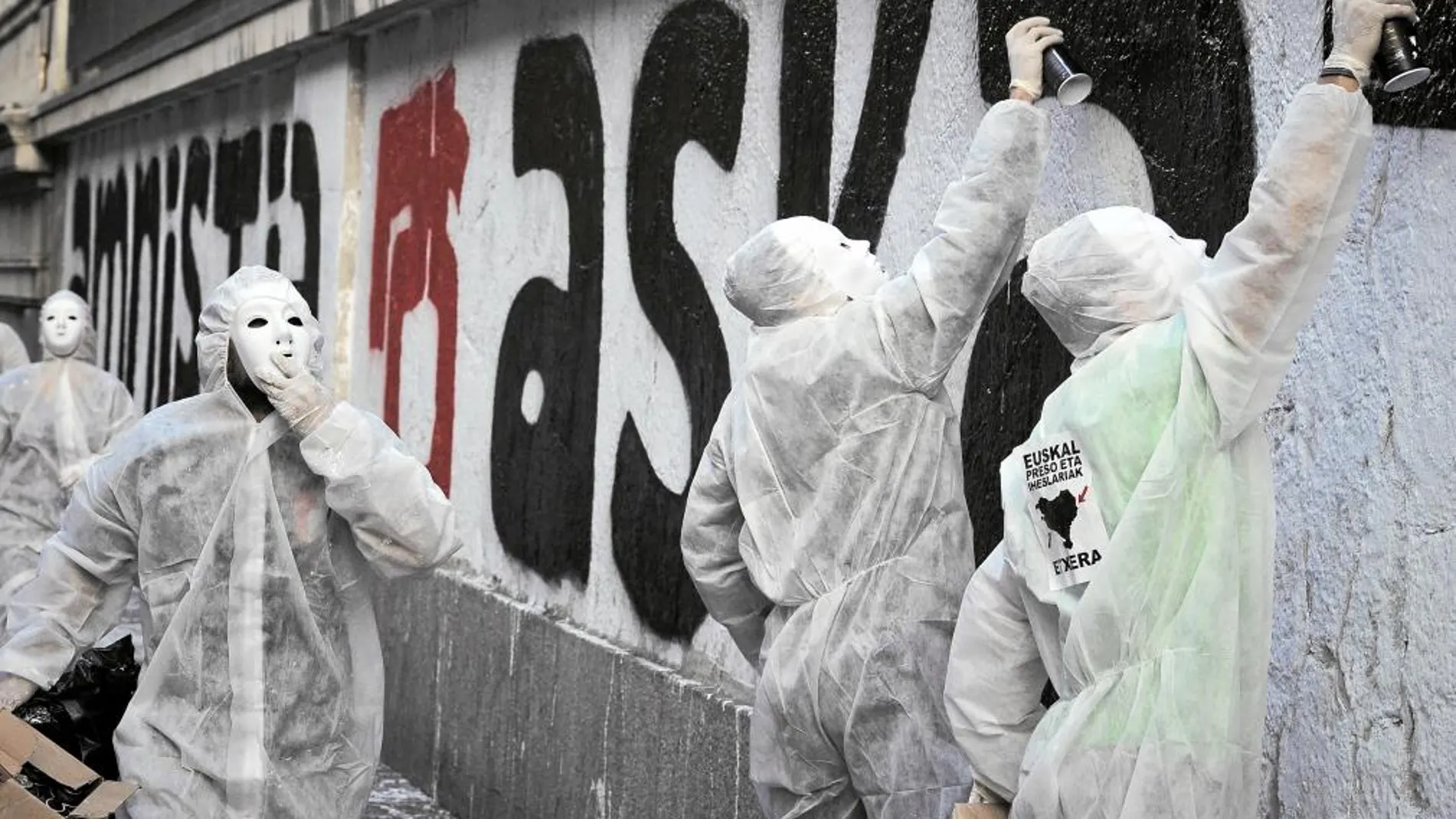 Varios encapuchados realizan una pintada a favor de la amnistía de los presos etarras