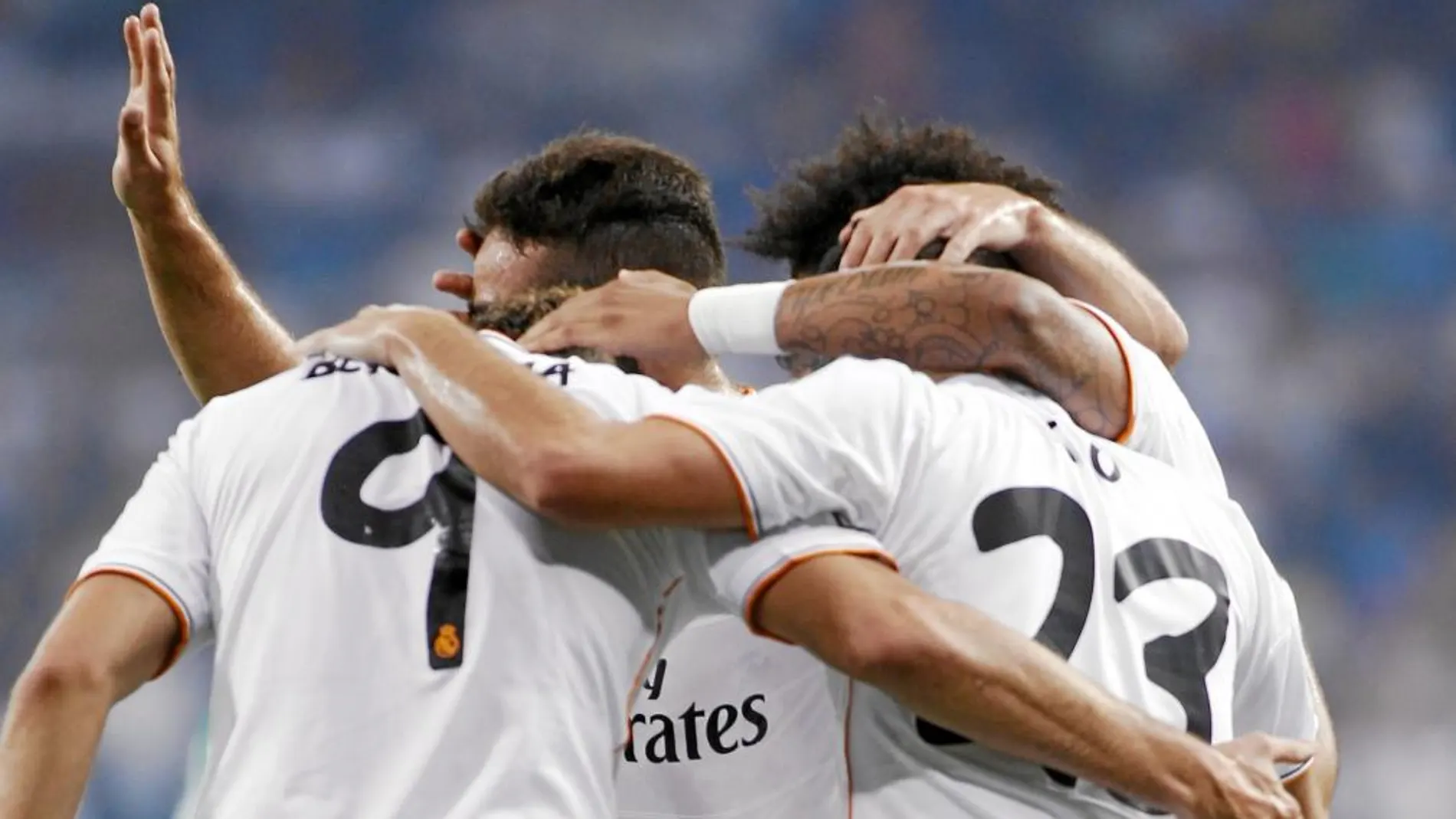 Bemnzema recibe la felicitación de varios compañeros tras marcar el primer gol del Madrid