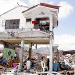 Una familia filipina observa el estado en el que ha quedado su casa tras el paso del tifón «Yolanda», en la ciudad de Tacloban