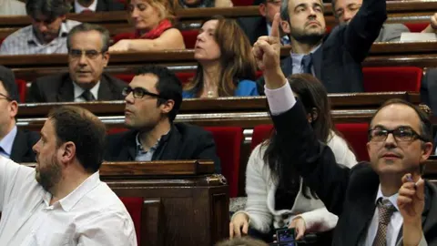 Los presidentes de los grupos parlamentarios de CiU, Jordi Turull (d) y de ERC, Oriol Junqueras (i) dan instrucciones de voto afirmativo.
