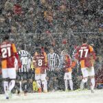 Jugadores del galatasary y del Juventus bajo la intebnsa nevada en el estadio