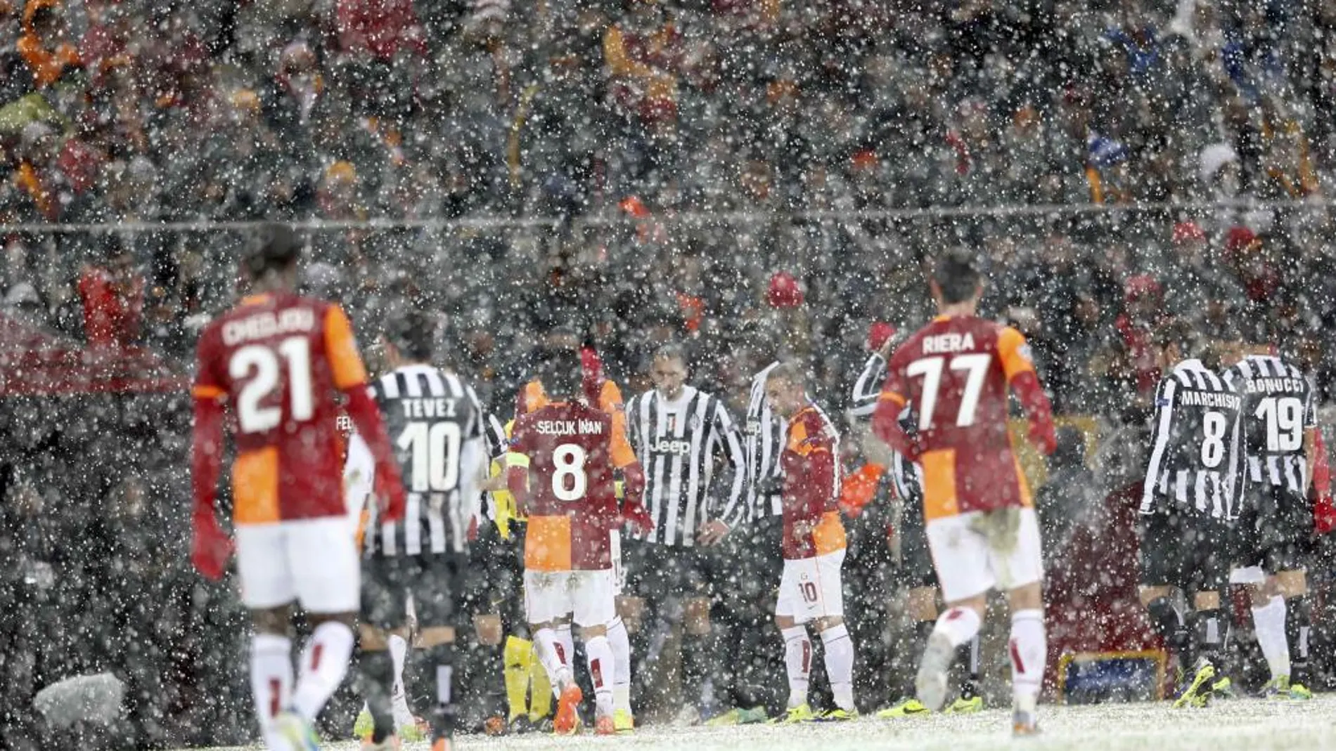 Jugadores del galatasary y del Juventus bajo la intebnsa nevada en el estadio