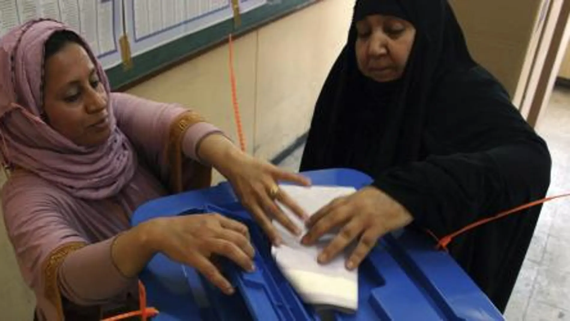 Una mujer iraquí deposita su papeleta para las elecciones parlamentarias en un centro electoral en Bagdad.