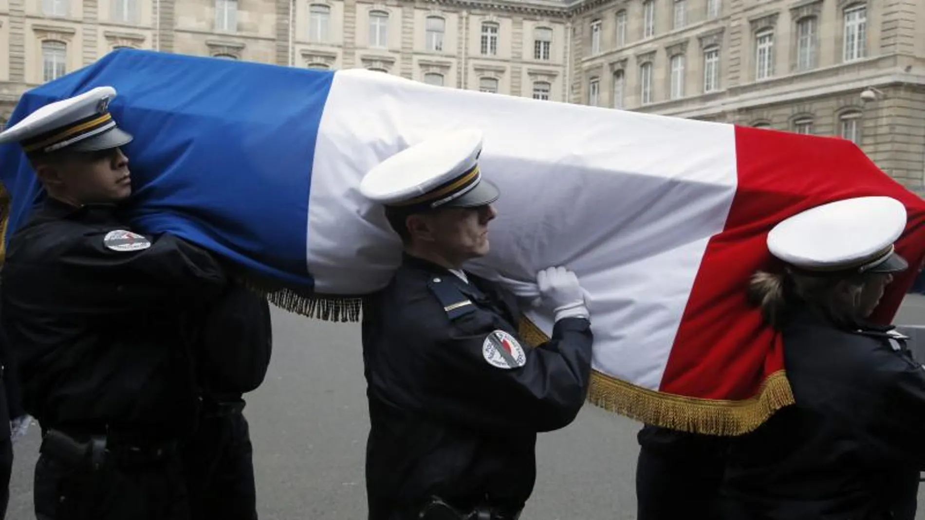 Policías portan el féretro de uno de sus compañeros asesinados en los ataques terroristas de la semana pasada durante su funeral en París (Francia)