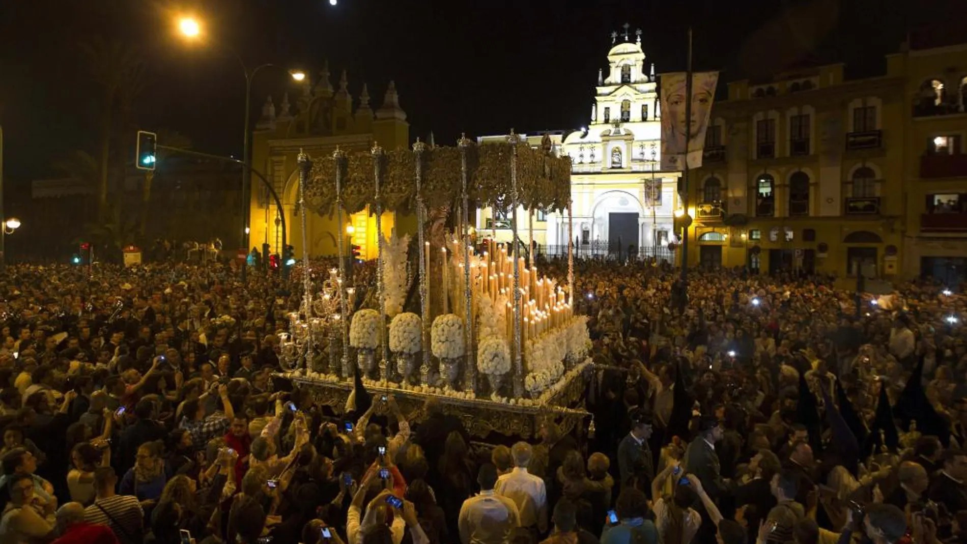 Sevillanos y turistas rodean el palio de la Esperanza Macarena a su salida anoche para La 'Madrugá' de 2014.