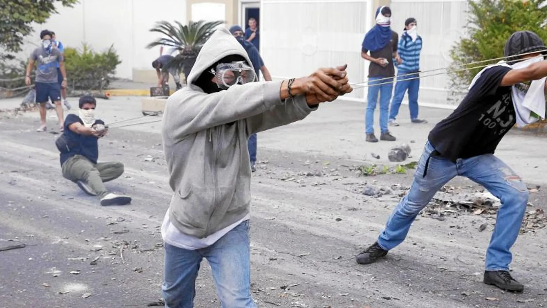 Un grupo de estudiantes se enfrenta, ayer, con piedras a la Policía durante una protesta en San Cristóbal