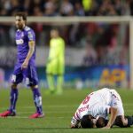 El jugador del Sevilla, Carlos Bacca en el suelo junto al jugador del Espanyol, Jose Alberto Canas