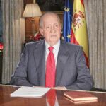 A la izqui. el Belén; sobre la mesa la Constitucuión y la derecha banderas de España y la UE