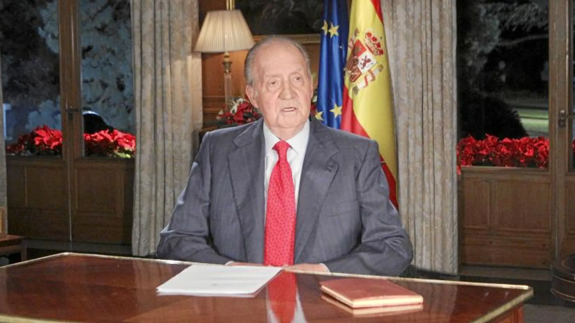 A la izqui. el Belén; sobre la mesa la Constitucuión y la derecha banderas de España y la UE