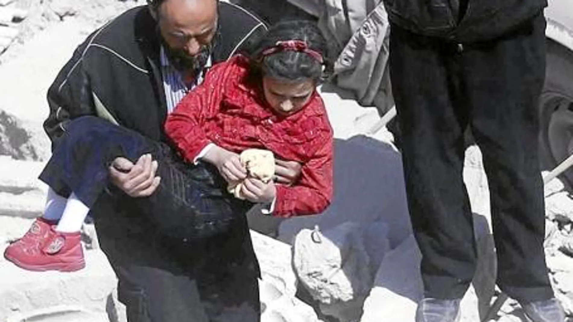 Un hombre lleva en brazos a una niña tras un bombardeo en Douma