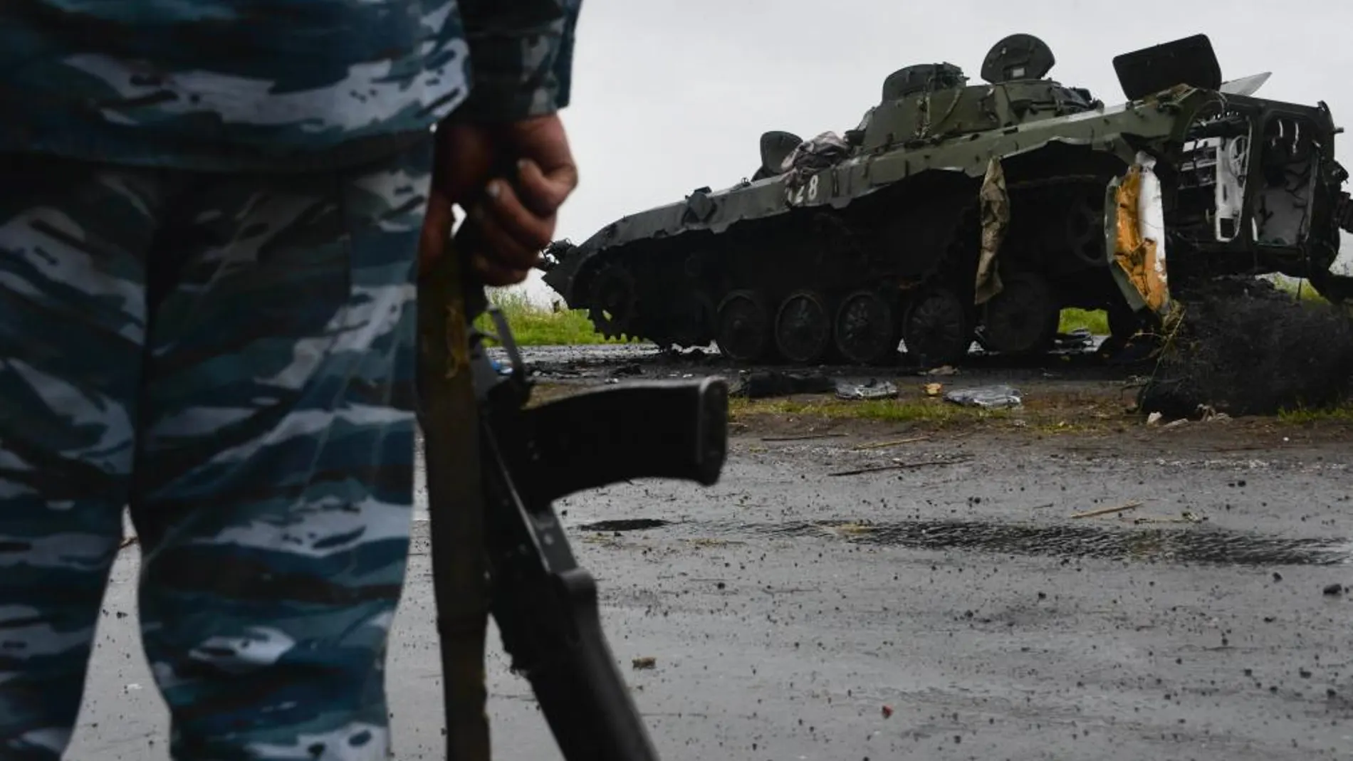 Un soldado ucraniano observa un tanque de guerra de rebeldes prorrusos destruido por un ataque del ejército ucraniano el 7 de julio de 2014, en Slaviansk (Ucrania).