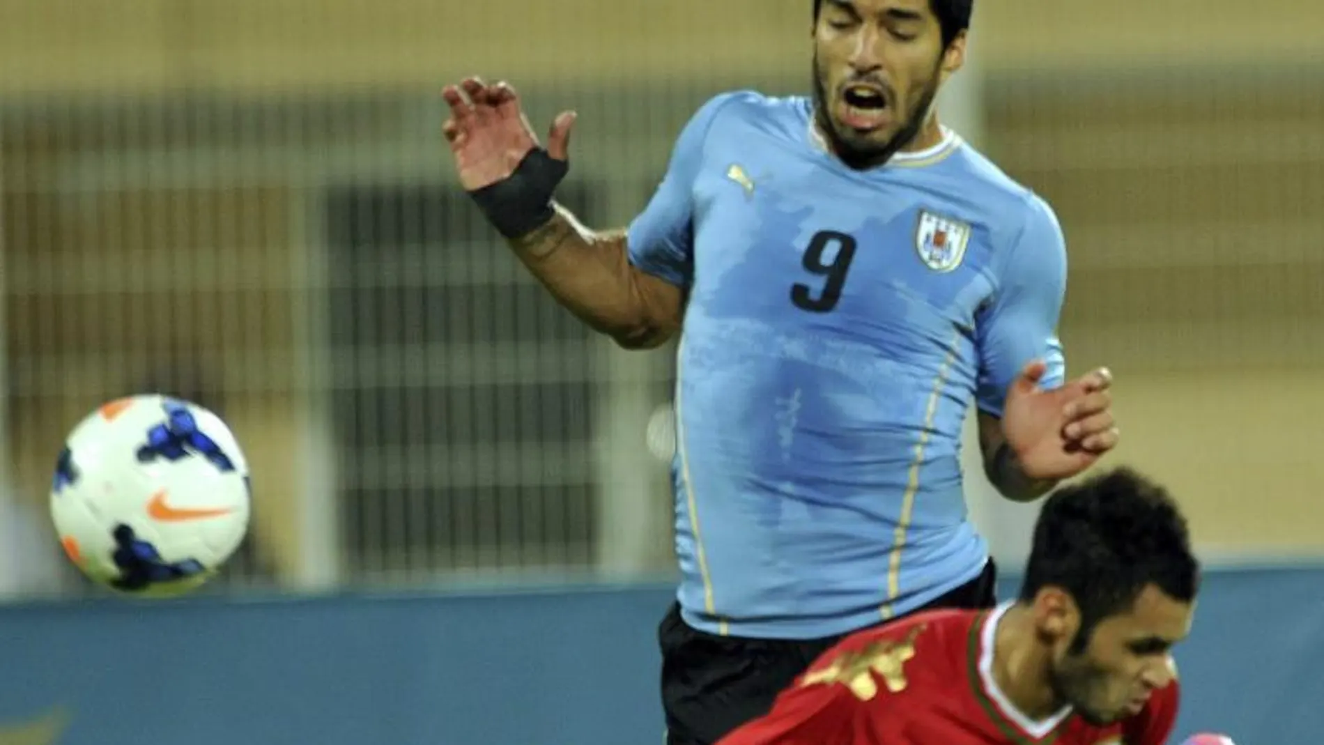 El delantero uruguayo Luis Suárez pelea por el control del balón con el jugador de Omán, Ali AlBusyydy