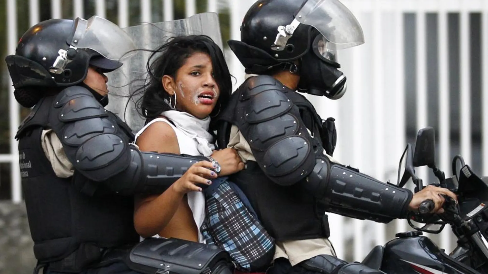 Miembros de la Policía Nacional Bolivariana (PNB) detienen a una manifestante opositora durante nuevos enfrentamientos en la Plaza Altamira de Caracas (Venezuela)