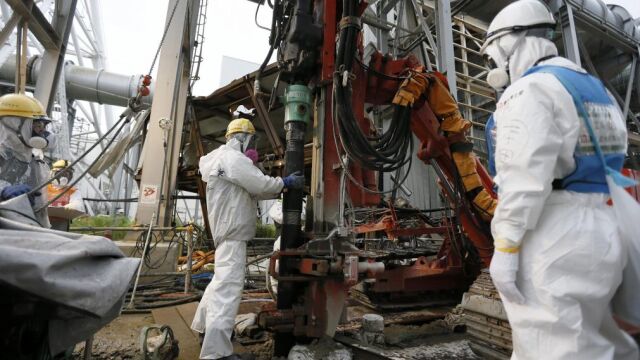 Varios trabajadores construyen un muro de hielo para congelar el agua radiactiva en la planta nuclear de Fukushima.