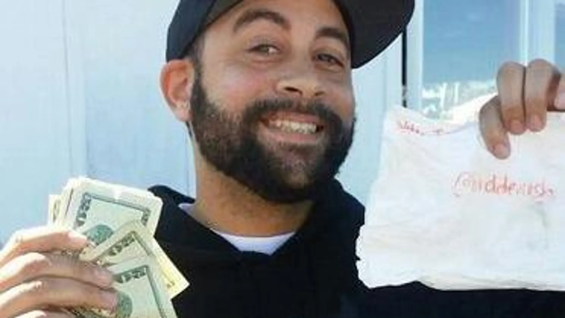 Un hombre posa con el dinero encontrado gracias a las pistas de Hidden Cash