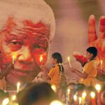 TRIBUTO MUNDIAL. Alumnos indios posan unas velas en un retrato de Mandela en Chenai
