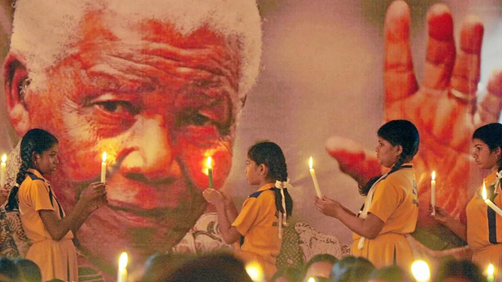TRIBUTO MUNDIAL. Alumnos indios posan unas velas en un retrato de Mandela en Chenai