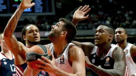 El ala-pívot del Real Madrid Felipe Reyes entra a canasta ante los jugadores de FC Bayern Munich Chevon Troutman (i) y Deon Thompson