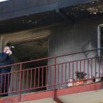 Un agente de la policía científica toma fotos en el balcón de la vivienda incendiada