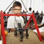Un niño con su invento: un columpio para niños en silla de ruedas