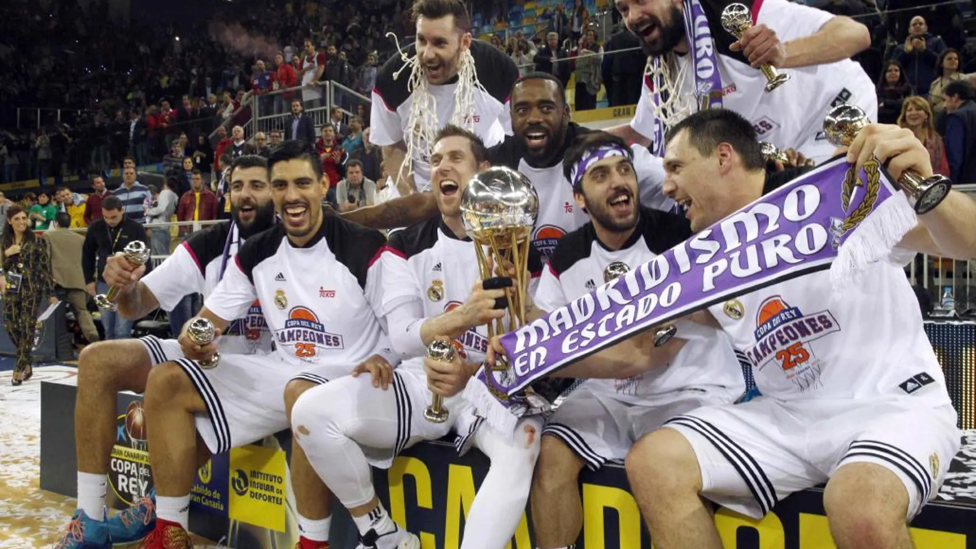 Los jugadores del Real Madrid posan con el trofeo tras conseguir hoy la vigésimo quinta Copa del Rey de baloncesto.