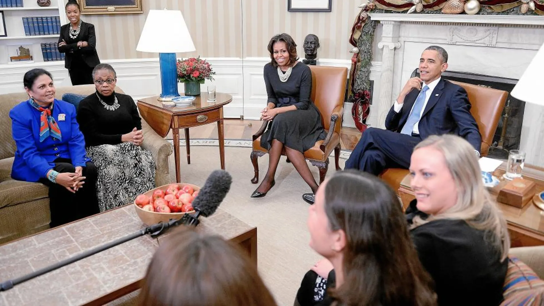 Barack y Michelle Obama charlan, ayer, en la Casa Blanca con un grupo de mujeres sobre la reforma sanitaria