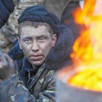 Un manifestante fuma un cigarrillo en una barricada de Kiev