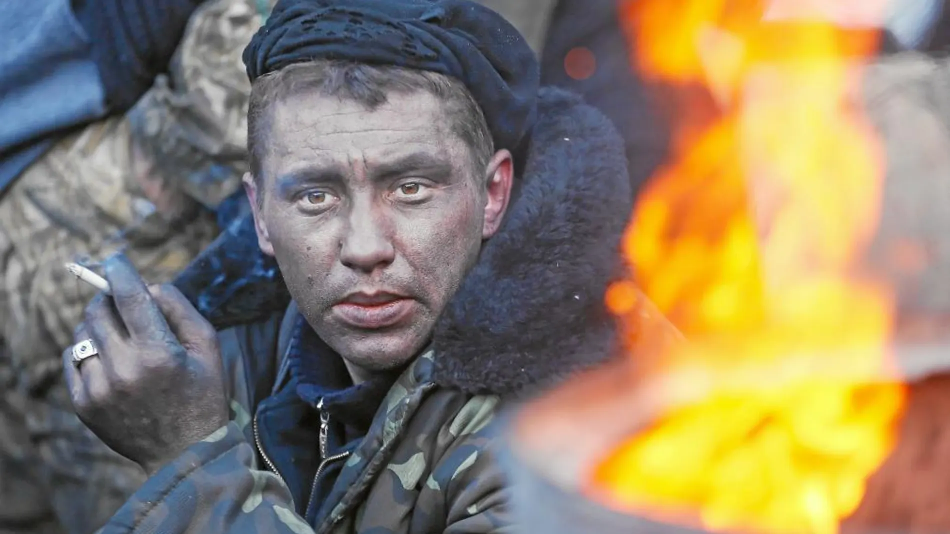 Un manifestante fuma un cigarrillo en una barricada de Kiev