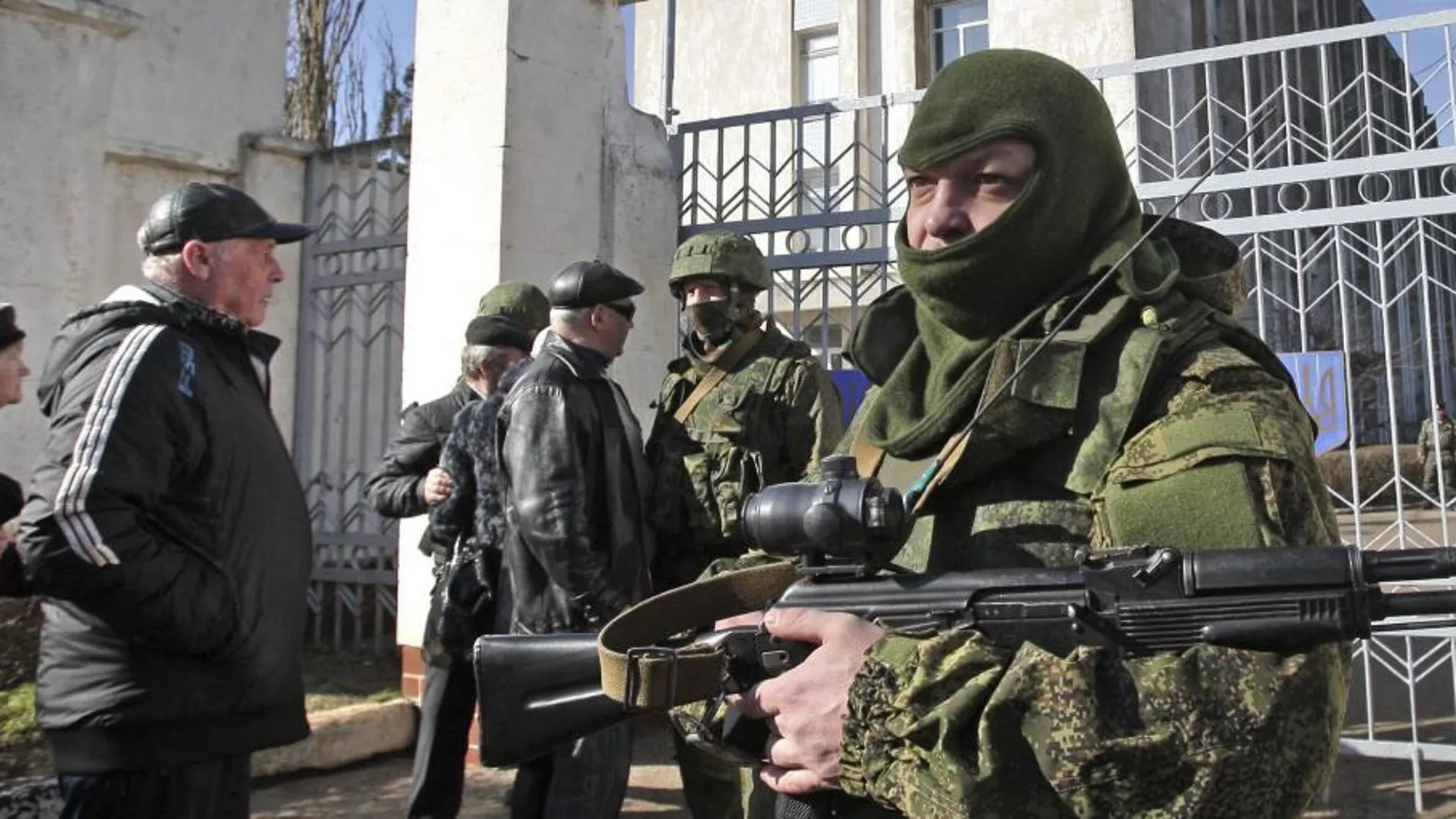 KIUn soldado armado sin identificar, presuntamente ruso, bloquea la entrada a la base naval ucraniana de Novoozerniy, cerca de Feodosia, a las afueras de Simferópol