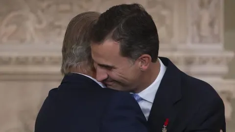 El Rey Juan Carlos besa al Príncipe de Asturias tras firmar la ley orgánica por la que se hace efectiva su abdicación