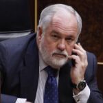 Arias Cañete habla por teléfono en los escaños del Congreso de los Diputados