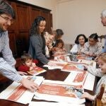 Javier, Elia, sus cinco hijos y los abuelos con carteles del día de la familia