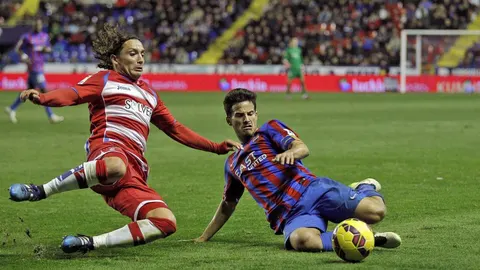 El centrocampista del Levante UD, Rubén García (d), disputa un balón con el jugador chileno del Granada, Manuel Rolando Iturra