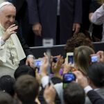 El Papa Francisco saluda a sus seguidores que le fotografían antes de comenzar la audiencia pública de los miércoles en el Aula Nervi (Vaticano)
