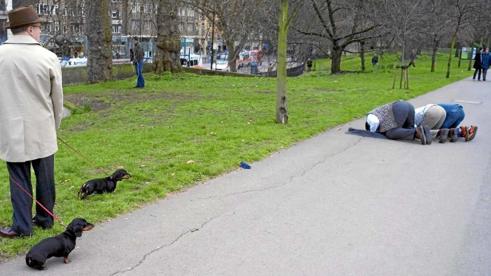 Un hombre observa a tres musulmanes rezando en el icónico Hyde Park, en Londres