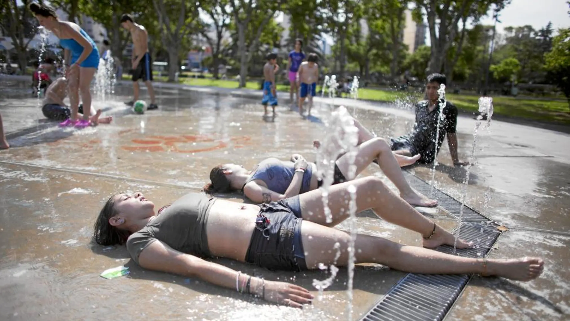 Niños y jóvenes se refrescan en una fuenta de Buenos Aires ante la ola de calor que sufre la capital