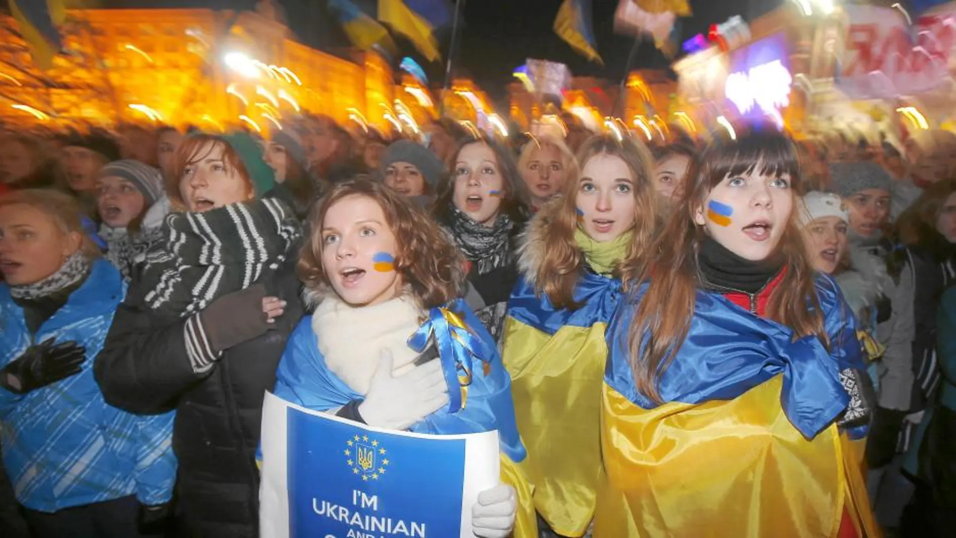Un grupo de manifestantes ucranianos cantan el himno nacional durante una manifestación, ayer, en la plaza de Europa de Kiev