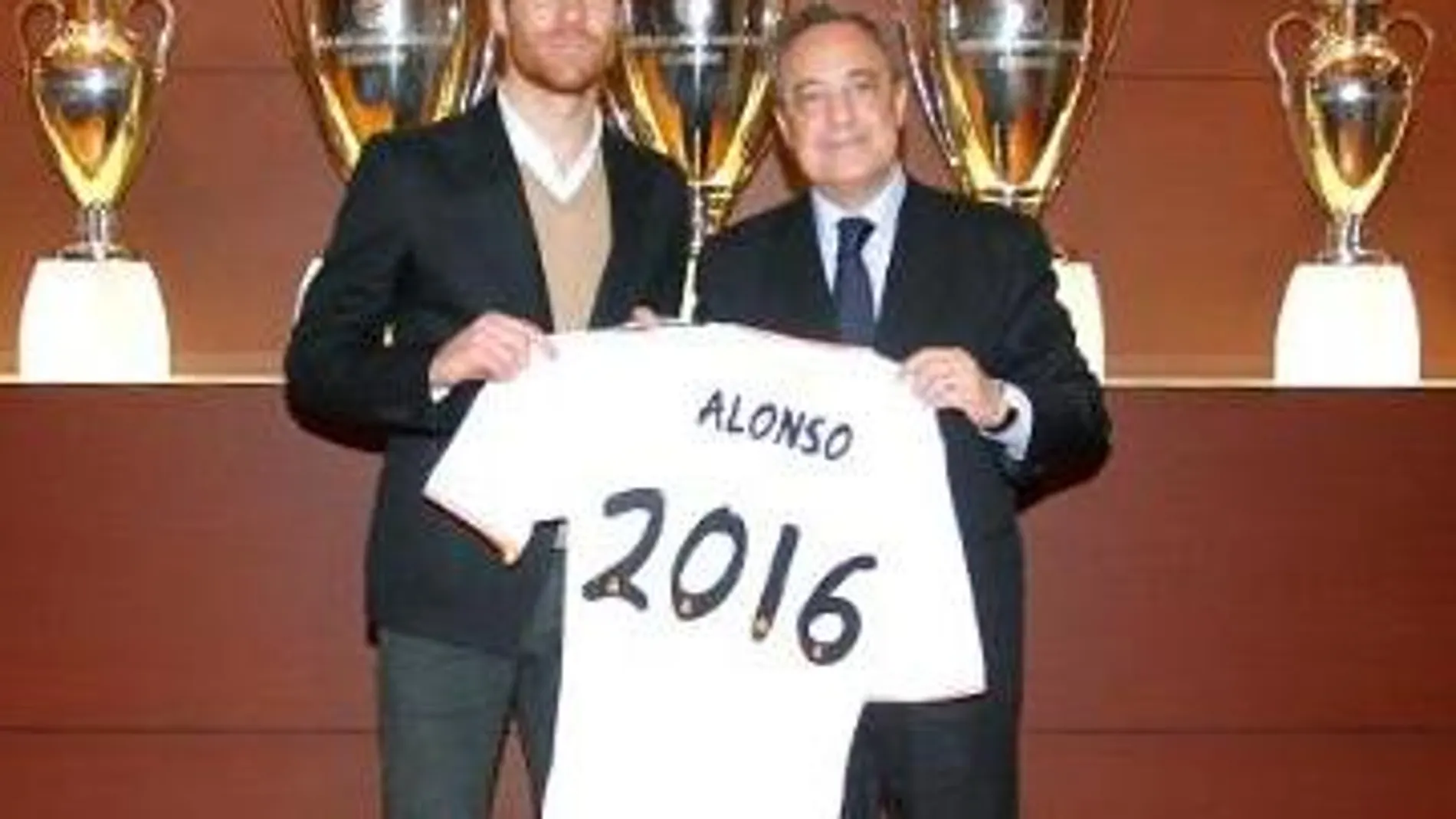 Xabi Alonso y Florentino Pérez posan con una camiseta del Real Madrid tras la firma de la renovación.