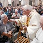 El cardenal arzobispo de Valencia ofrece la comunión a unos feligreses