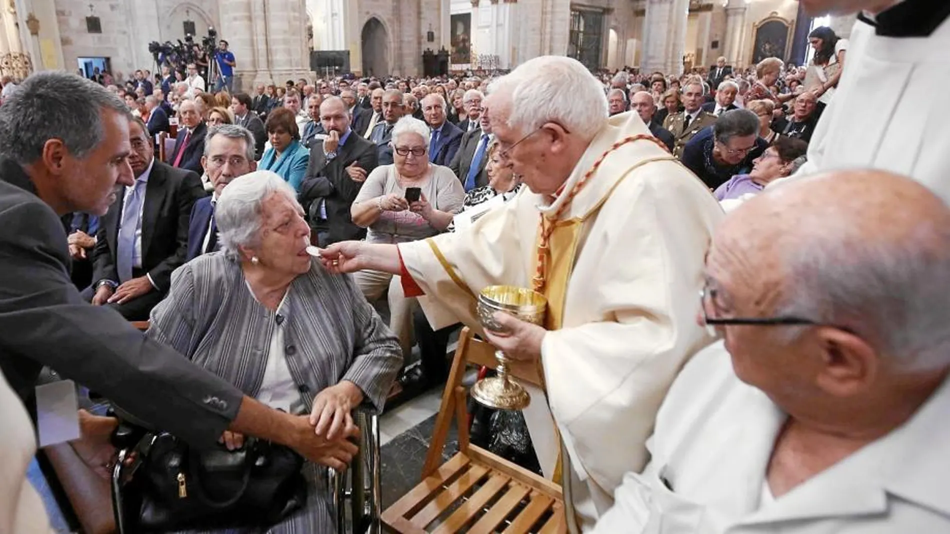 El cardenal arzobispo de Valencia ofrece la comunión a unos feligreses