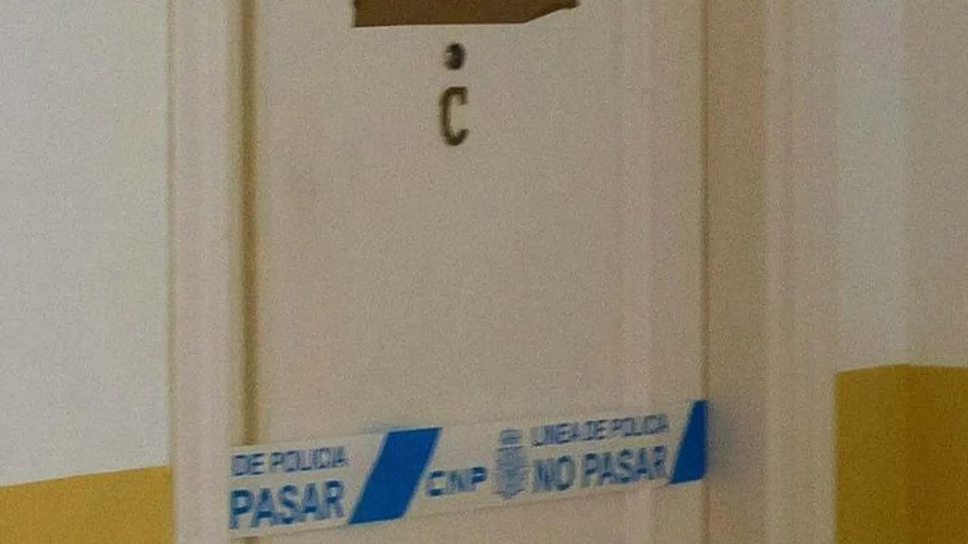 Vista de la puerta precintada de la vivienda en la localidad sevillana de Alcalá de Guadaira donde residían el matrimonio fallecido y sus dos hijas,