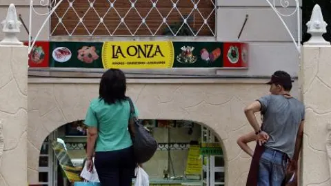 Dos cubanos, ante uno de los negocios privados que ha permitido el régimen.