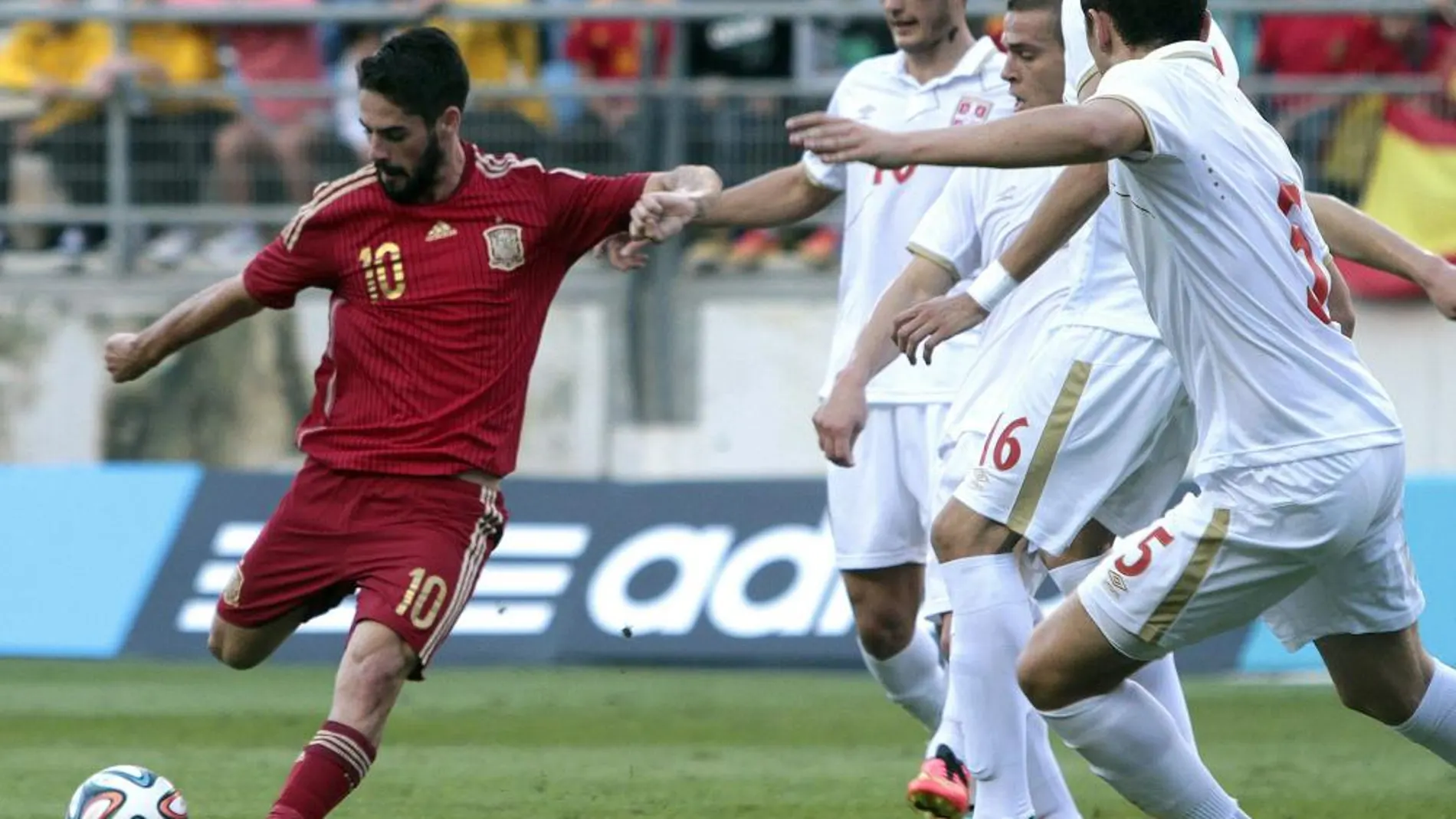 El centrocampista español Francisco Alarcón “Isco” (i) con el balón ante varios jugadores de la selección de Serbia
