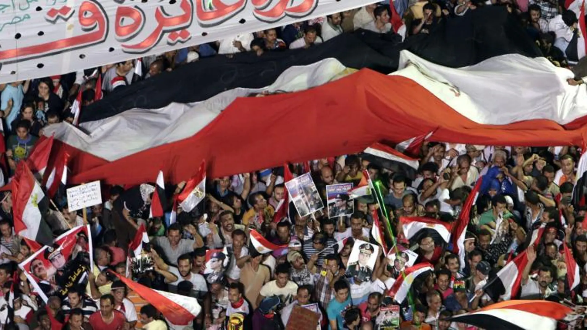 Varias personas ondean una bandera egipcia, durante una manifestación a favor de las fuerzas armadas en la plaza Tahrir en El Cairo