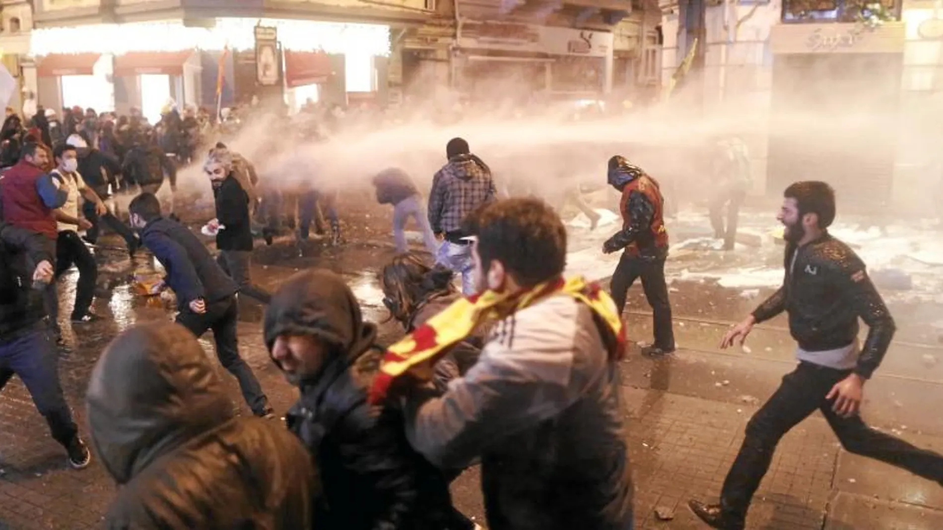 Manifestantes turcos huyen del gas lacrimógeno lanzado ayer por la Policía en Estambul