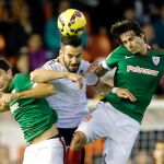 El delantero del Valencia Negredo cabecea un balón entre Etxeita e Iturraspe, ambos del Athletic de Bilbao