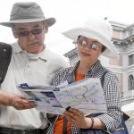 Una pareja de turistas asiáticos paseando por el paseo del Prado