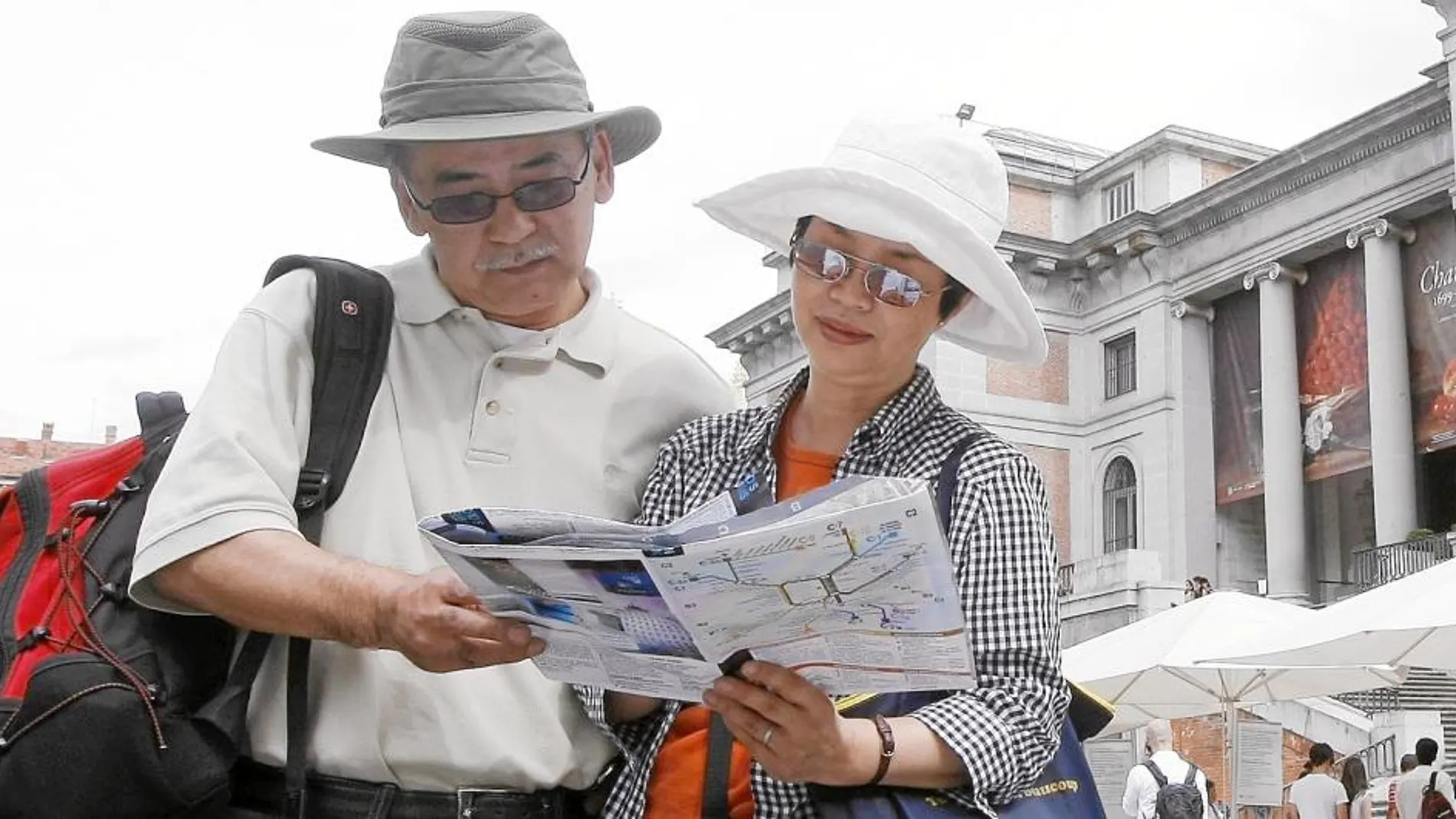 Una pareja de turistas asiáticos paseando por el paseo del Prado